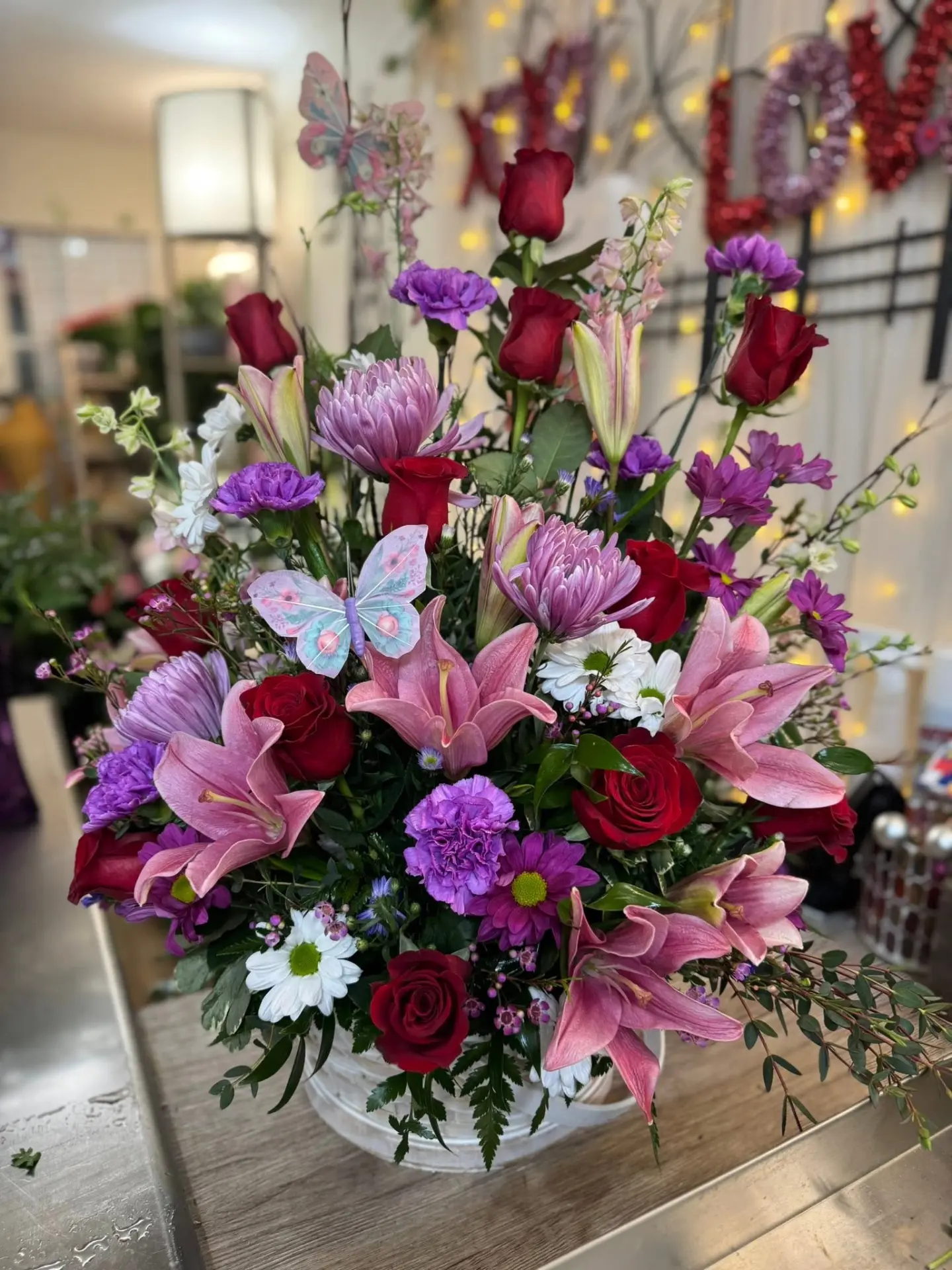 Pink lilies and red roses in a colorful celebratory arrangement