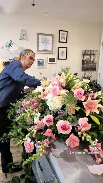 Angela working on a large pink floral arrangement in her studio